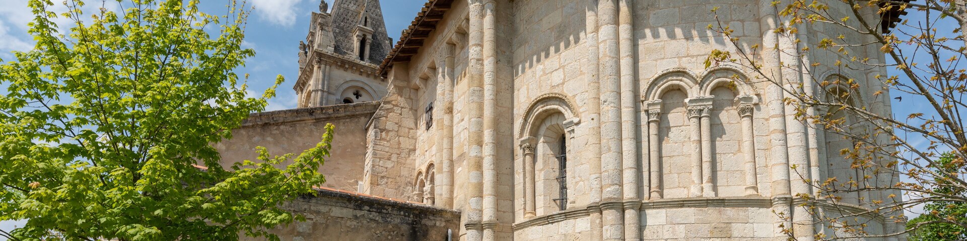 Una iglesia de piedra histórica con un campanario y una puerta roja.