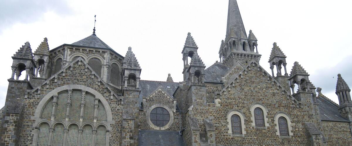 A historic church with intricate stone architecture, multiple spires, and a prominent central dome.