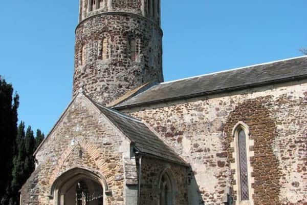 A historic stone church with a bell tower and arched windows.
