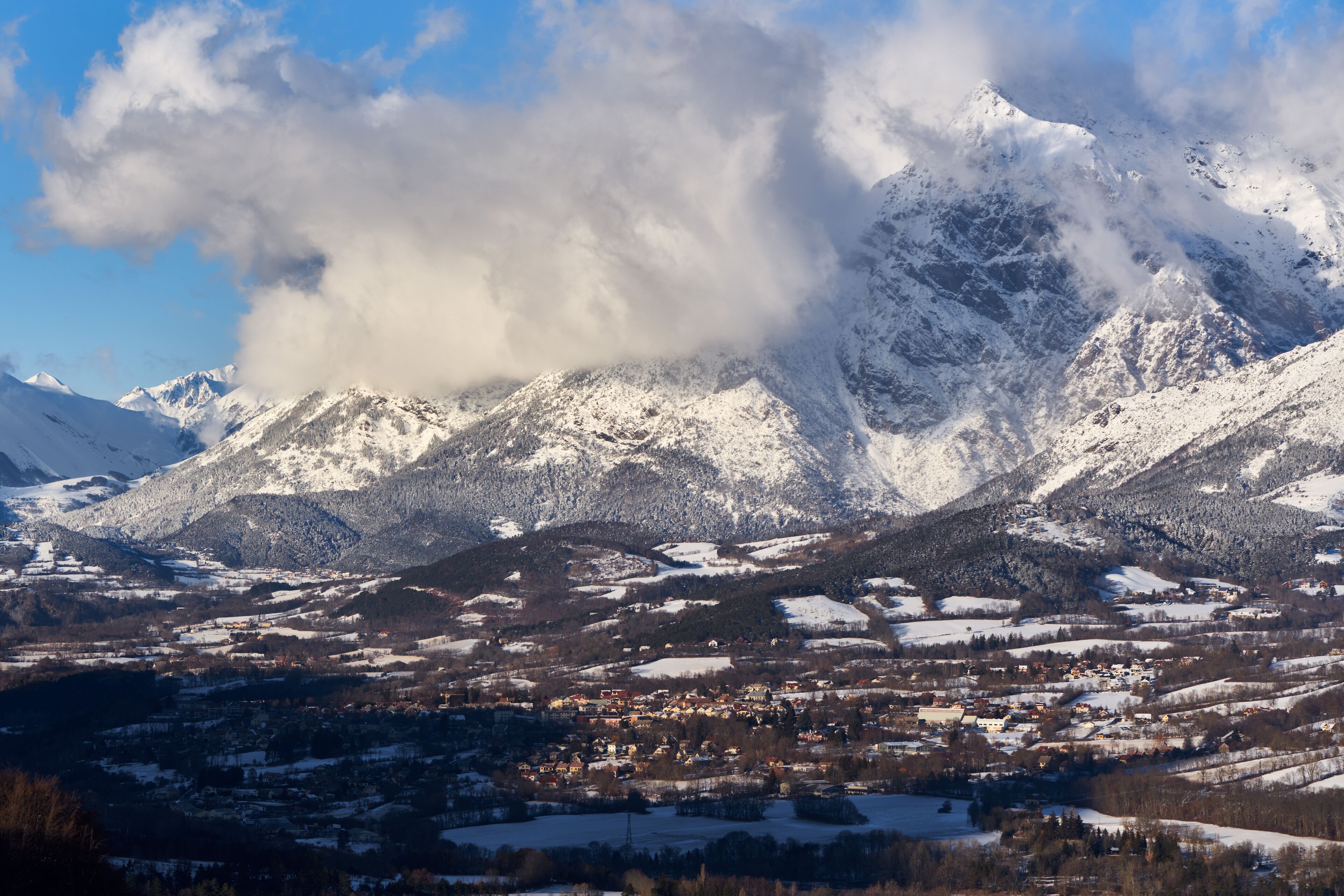 A snow-covered mountain range with a town nestled in the valley.