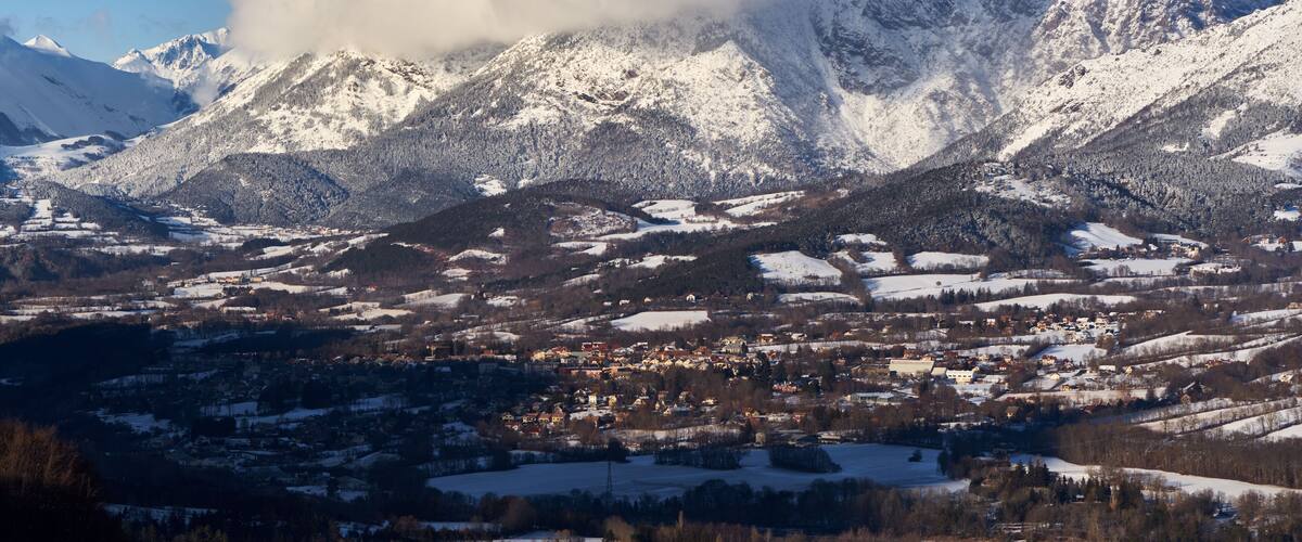 A snow-covered mountain range with a town nestled in the valley.