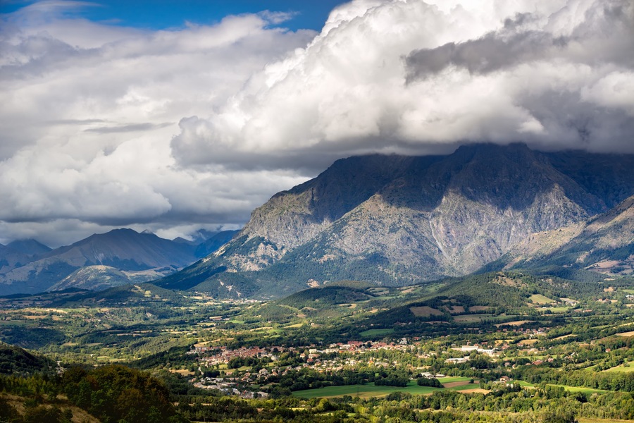 Saint Bonnet en Champsaur and the Petit Chaillol mountain peak in the clouds. Summer in the Southern French Alps. Hautes-Alpes, PACA Region, Champsaur, France
