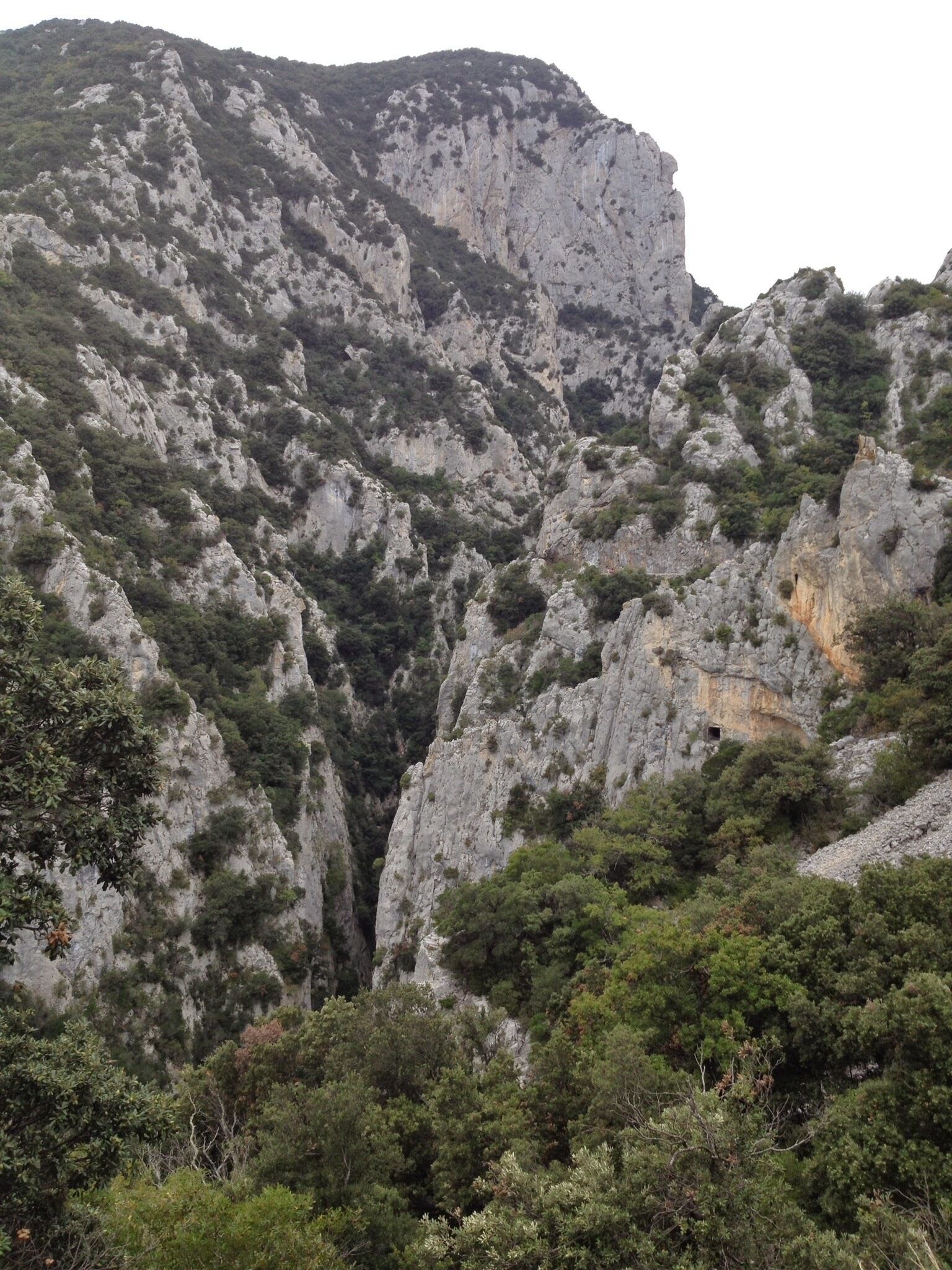 A rugged mountain landscape with steep cliffs and dense greenery.