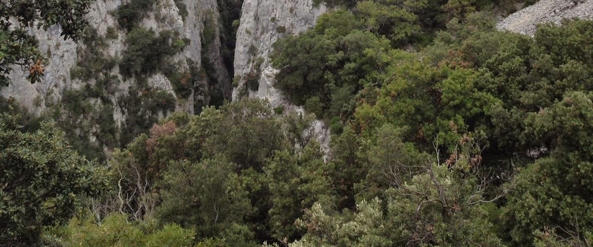 A rugged mountain landscape with steep cliffs and dense greenery.
