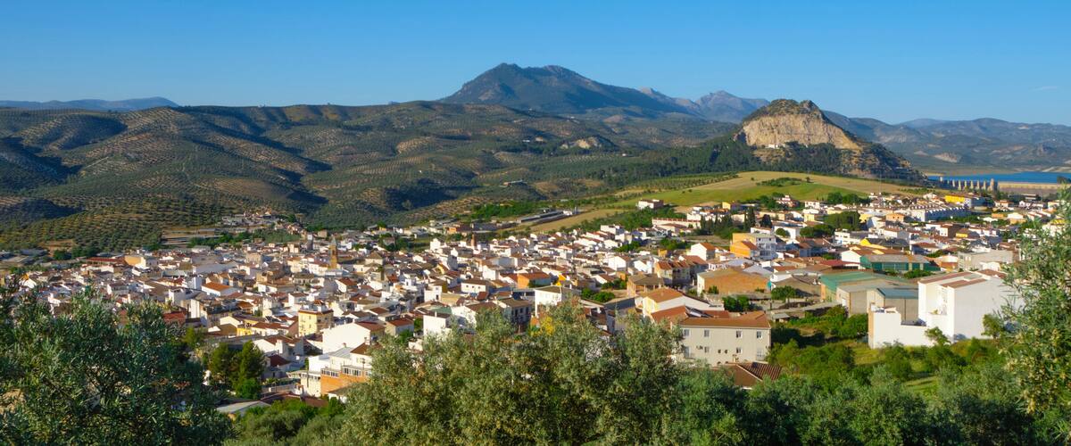 A town nestled in a valley with mountains in the background.