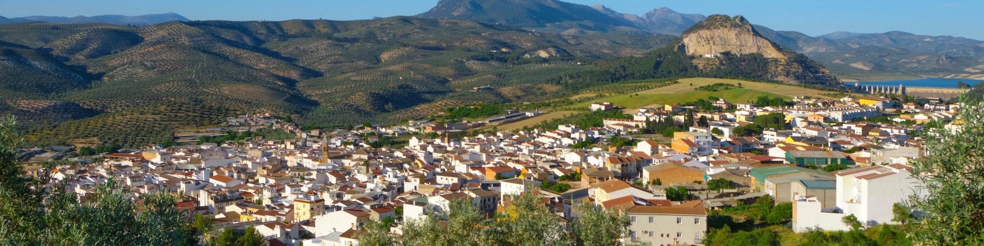 A town nestled in a valley with mountains in the background.