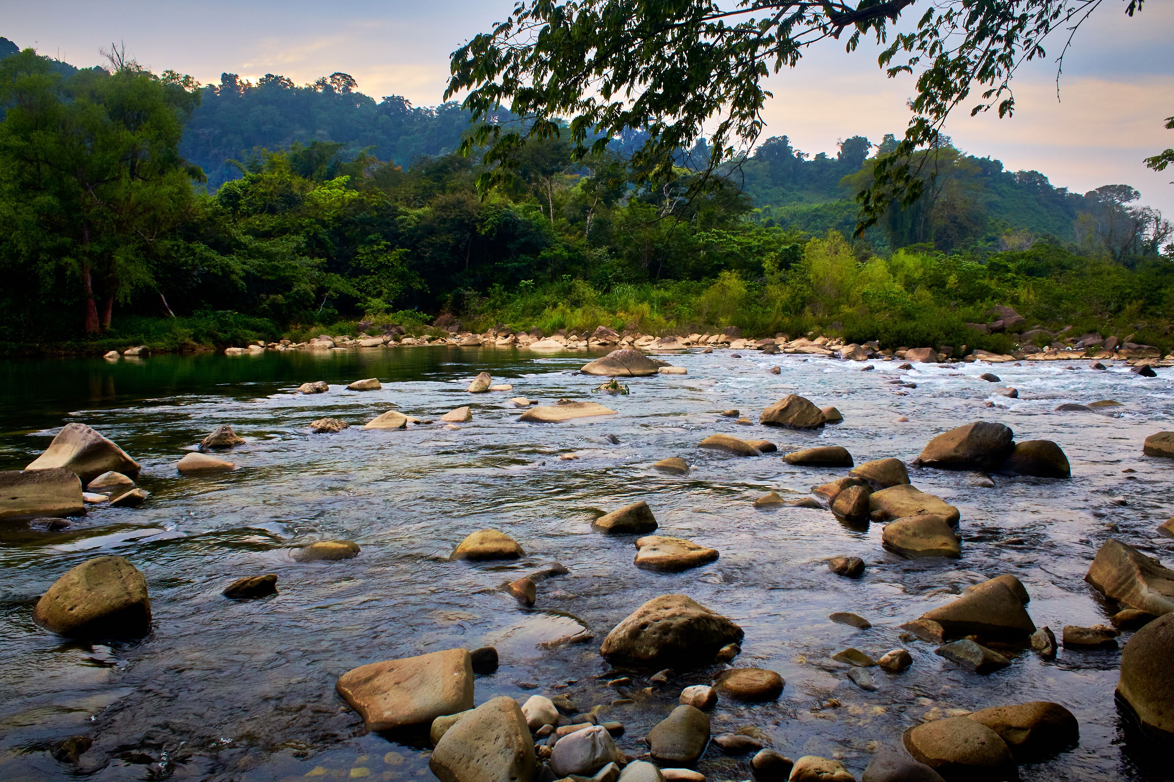 green river with a lot of rocks and jungle in the background with cloudy sky in filobobos river in martinez de la torre veracruz 