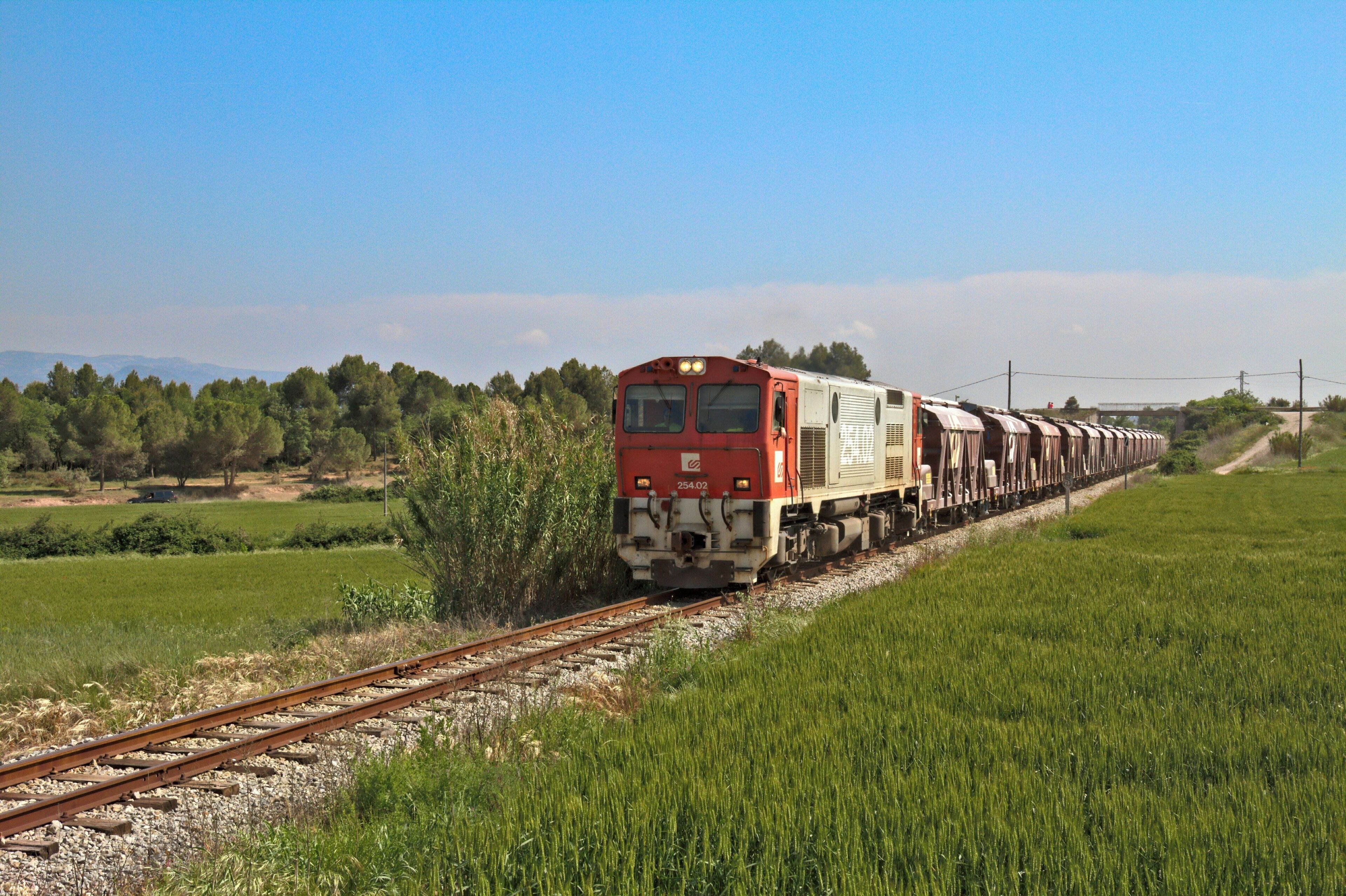 [CAT]: Moltes vegades penso en la sort que te un servidor, de tenir els ramals miners de Sallent i de Súria al costat de casa i poder gaudir de les circulacions i trasllats de material, com de les tones i tones de sal i potassa, cap als seus respectius destins. Quan vaig començar en el mon de la fotografia ferroviària, mai m'hagués imaginat les hores que hi dedicaria, ni les alegries i satisfaccions que m'ha arribat a donar, es una benedicció. A la foto, la 254.02 pujant un tall de tremuges buides cap a la mina de Sallent, deixant enrrere el Mas de Sant Iscle i les esglésies romàniques de Sant Iscle i Santa Victòria. [ES]: Muchas veces pienso en la suerte que tiene un servidor, de tener los ramales mineros de Sallent y de Súria al lado de casa y poder disfrutar de las circulaciones y traslados de material, como de las toneladas y toneladas de sal y potasa, hacia sus respectivos destinos. Cuando empecé en el mundo de la fotografía ferroviaria, nunca me imaginé las horas que le he dedicado, ni las alegrías y satisfacciones que me ha llegado a dar, es una bendición. En la foto, la 254.02 subiendo un corte de tolvas vacías hacia la mina de Sallent, dejando atrás el "Mas de Sant Iscle" y las iglesias románicas de "Sant Iscle" y "Santa Victòria".