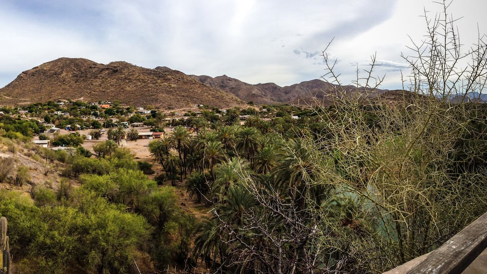A mountainous landscape with a small stone building and scattered houses.