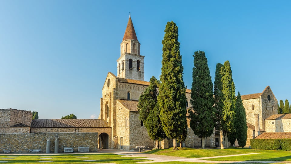 A historic church with a tall bell tower and a well-maintained lawn.