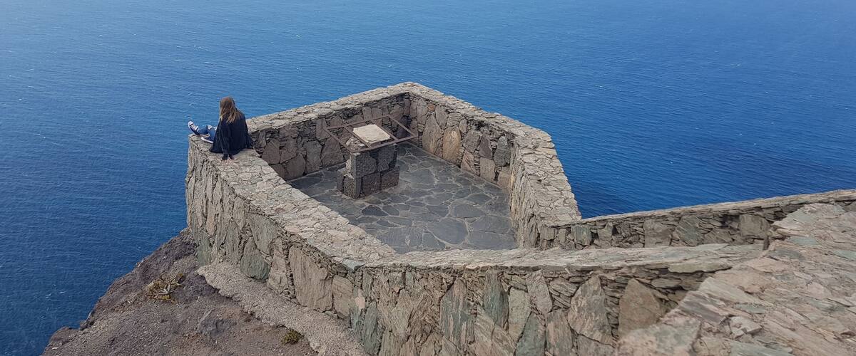 A stone structure overlooking a vast body of water.