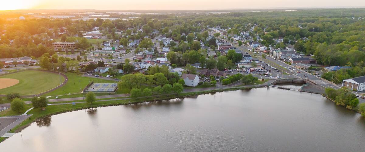 A river flowing through a town with houses and a baseball field.