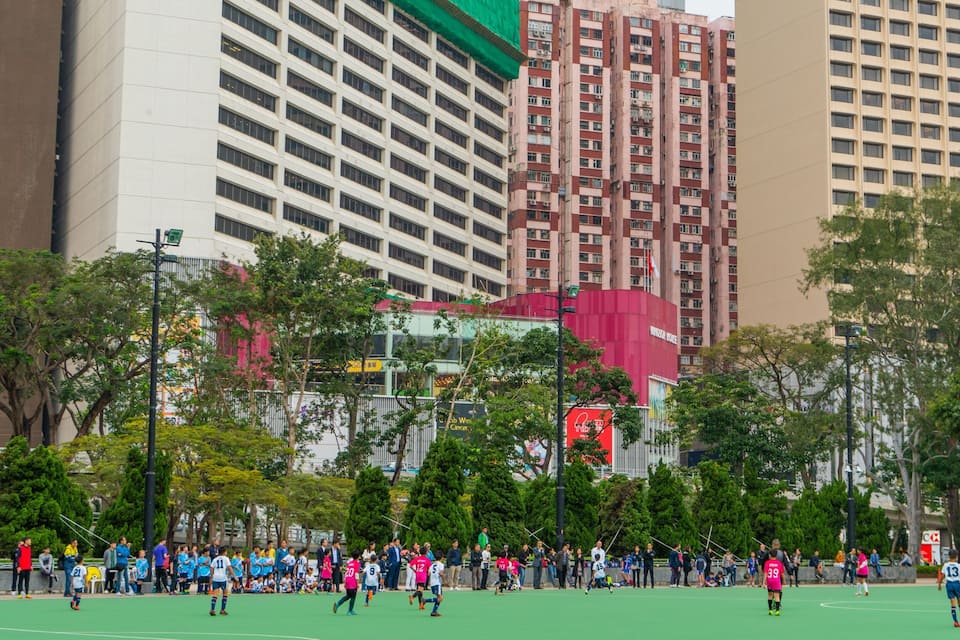 Um campo de futebol cercado por edifícios altos e árvores.