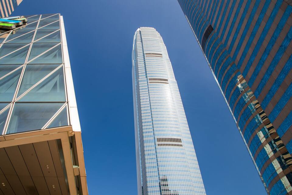 A tall skyscraper with a grid-like facade and a curved corner.
