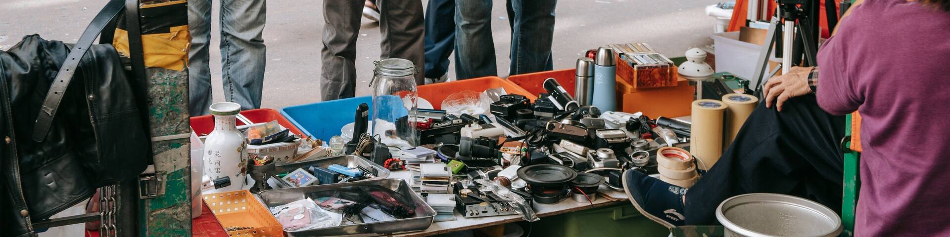 A street market with various electronic devices and accessories on display.