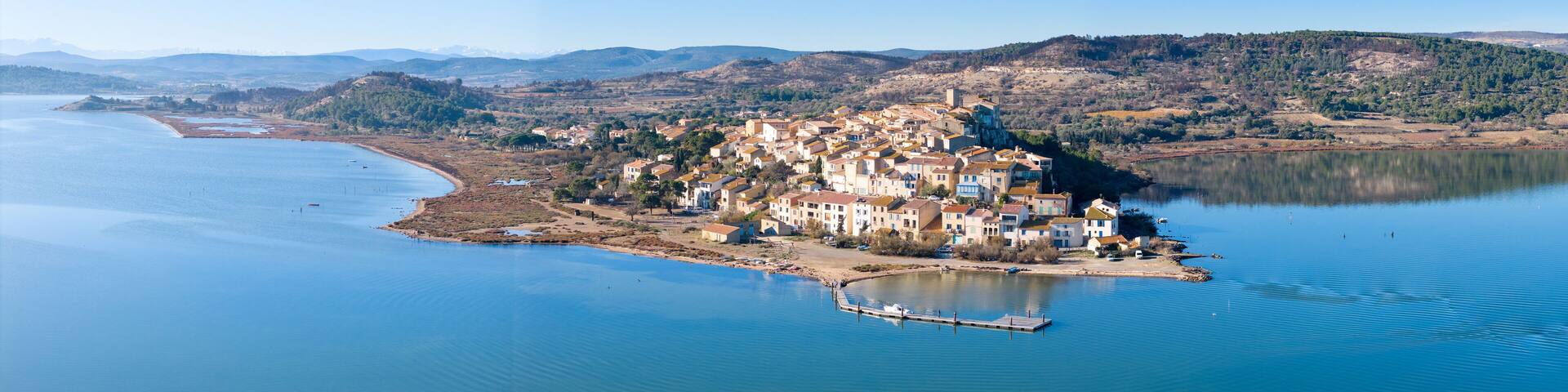 A coastal town with buildings on a peninsula surrounded by water.