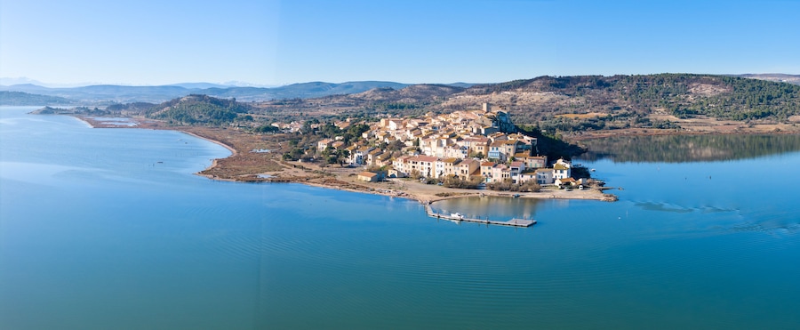 Un pueblo costero con edificios en una península rodeada de agua.