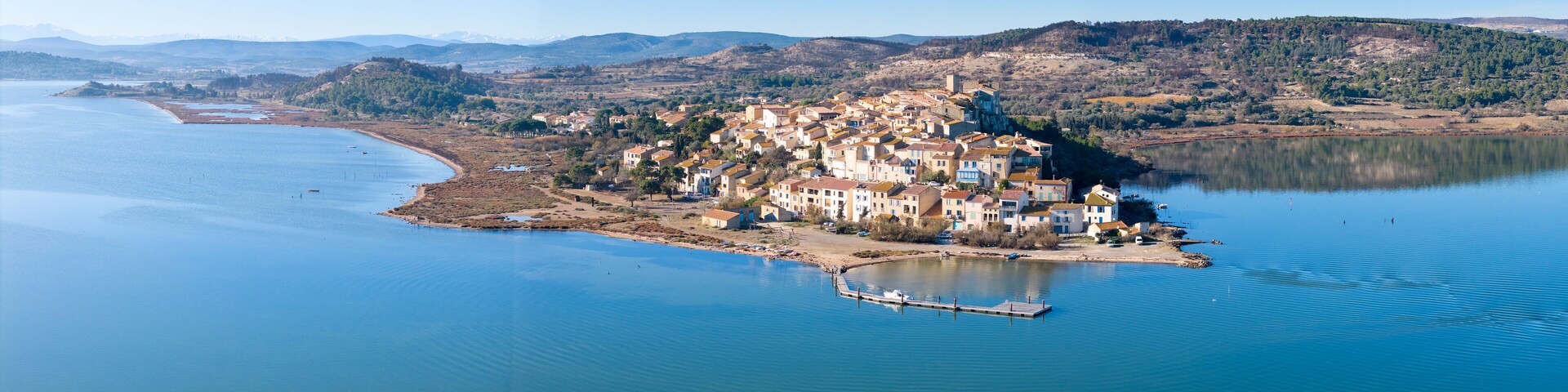 Un pueblo costero con edificios en una península rodeada de agua.