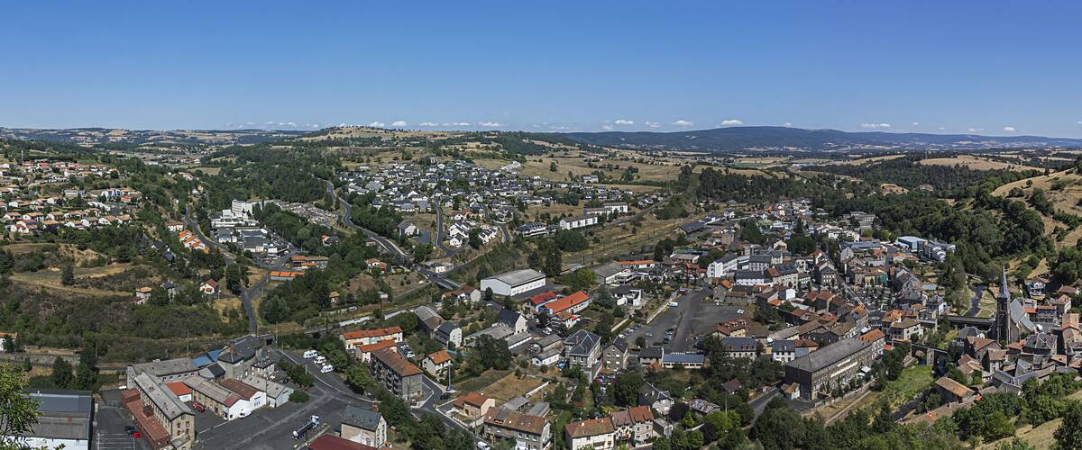 A town nestled in a valley with rolling hills and a clear blue sky.