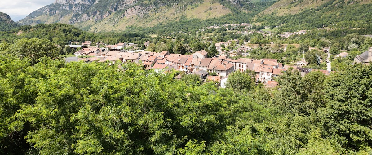 A town nestled in a valley with a prominent mountain in the background.
