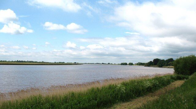 The Ouse at Saltmarshe, East Riding of Yorkshire, England. The Ouse is a big, wide river at this point, and at high tide it is above the level of the road in Saltmarshe village.