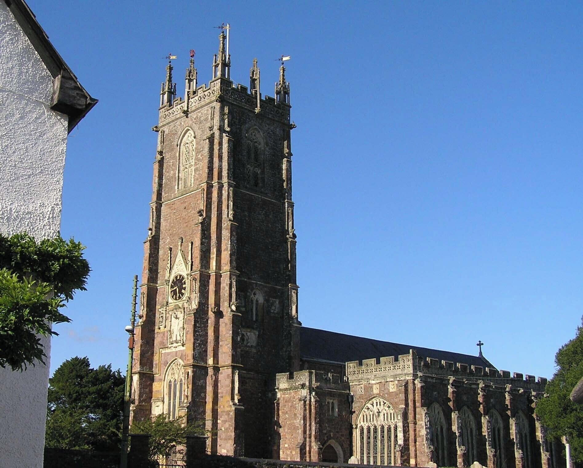 Una iglesia histórica con una torre alta y arquitectura gótica detallada.
