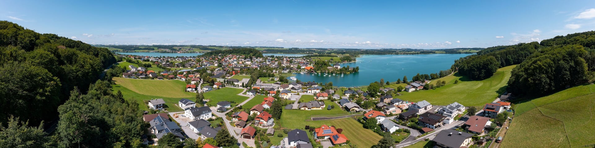 Austria, Salzburg, Mattsee, Drone panorama of lakeshore town in summer