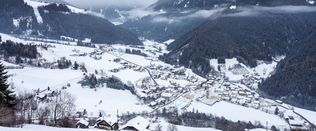 A snow-covered mountain village with houses and a church.