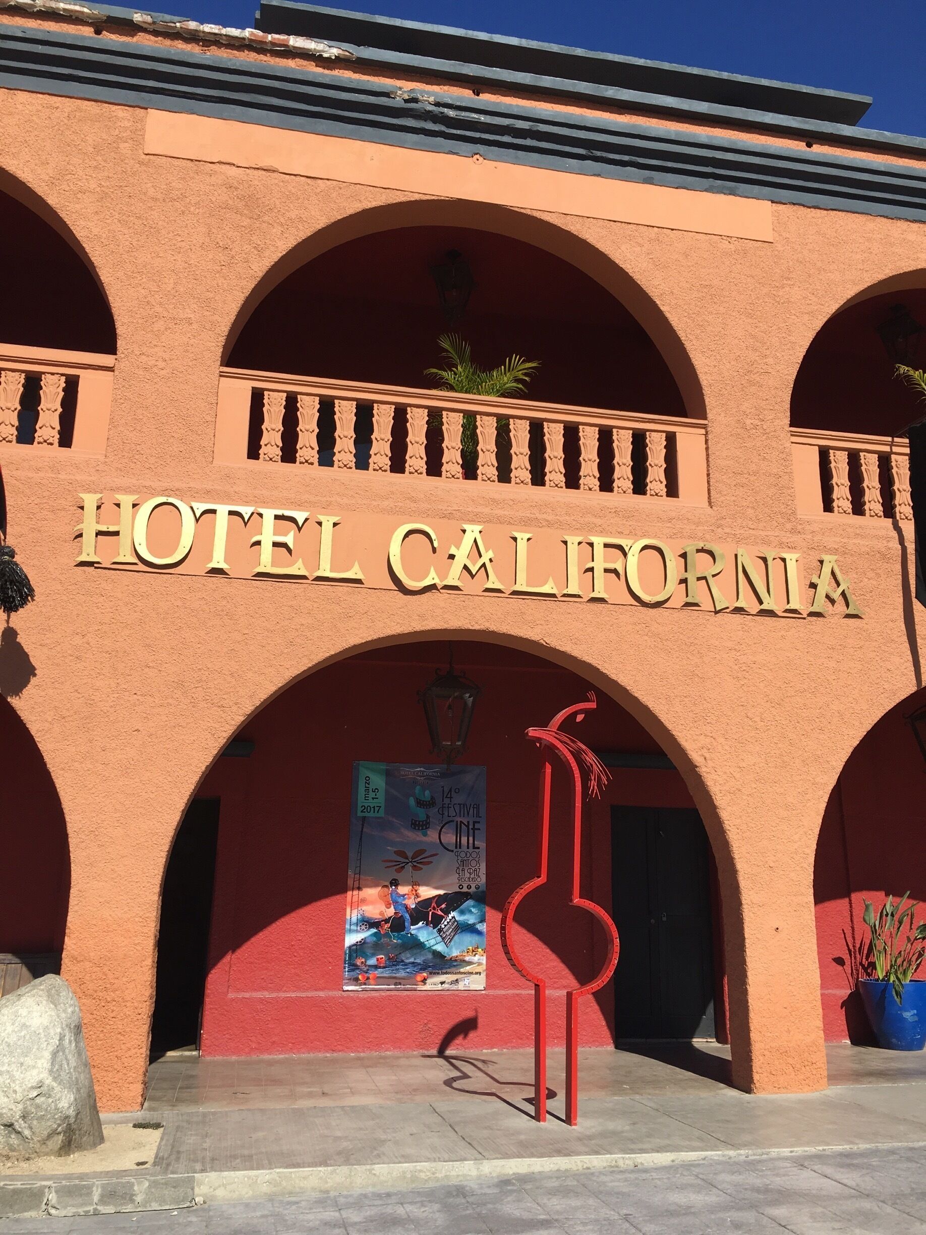 A building with the sign "HOTEL CALIFORNIA" and a poster for the 14th Festival Cine.