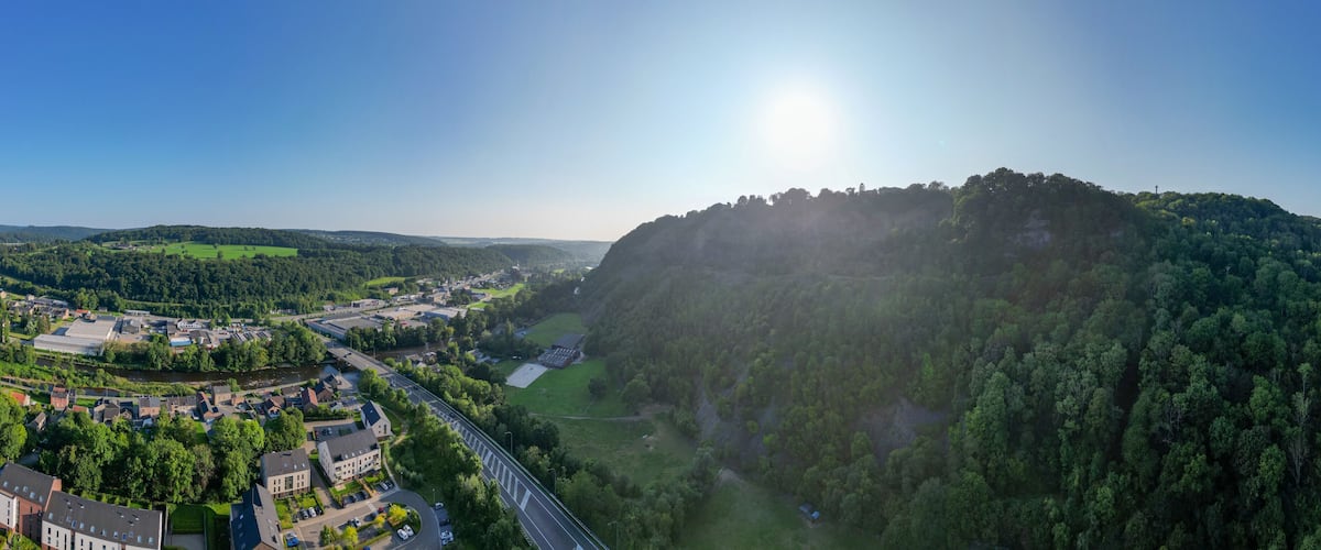 A river valley with a bridge, a town, and a forested hill.