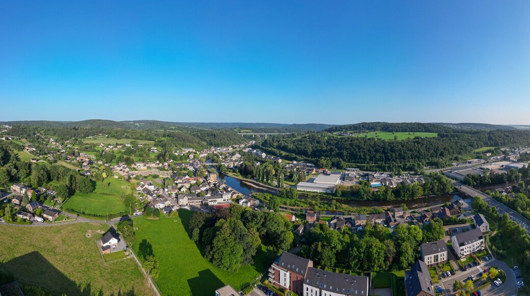 Sougne-Remouchamps, Aywaille, Liege, Wallonie, Belgium, August 10, 2025, An aerial view captures a winding river gracefully meandering through a lush and vibrant town under clear blue skies