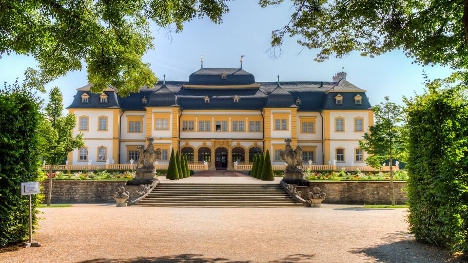 A grand building with a symmetrical facade, large windows, and a central entrance flanked by steps.