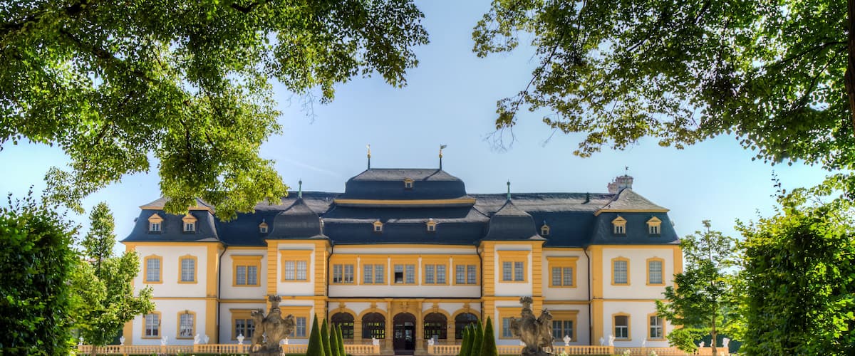 A grand building with a symmetrical facade, large windows, and a central entrance flanked by steps.
