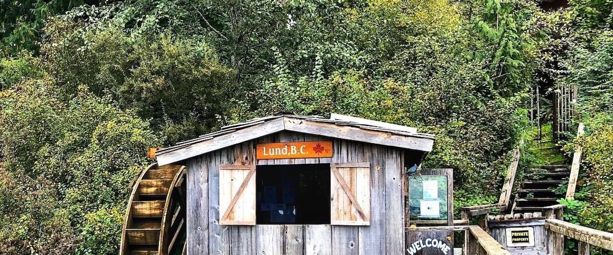 A wooden structure with a sign reading "Lund B.C." and a "WELCOME" sign.
