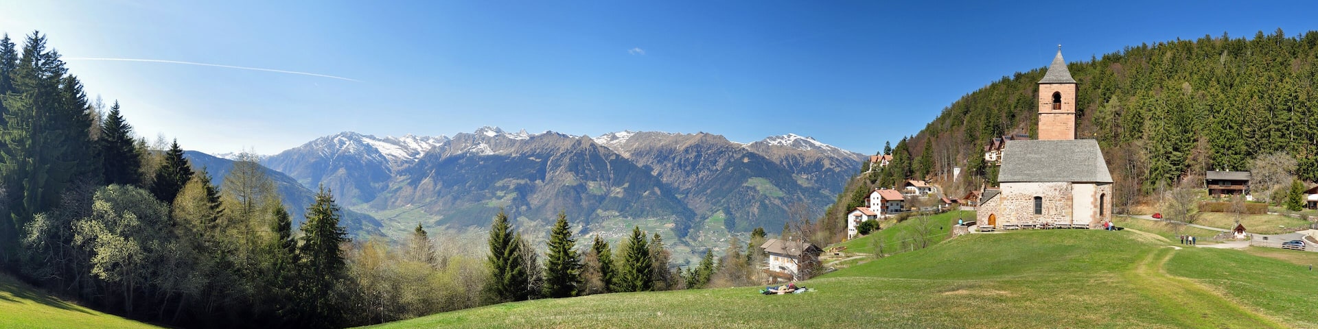 A church on a hill with a mountain backdrop.