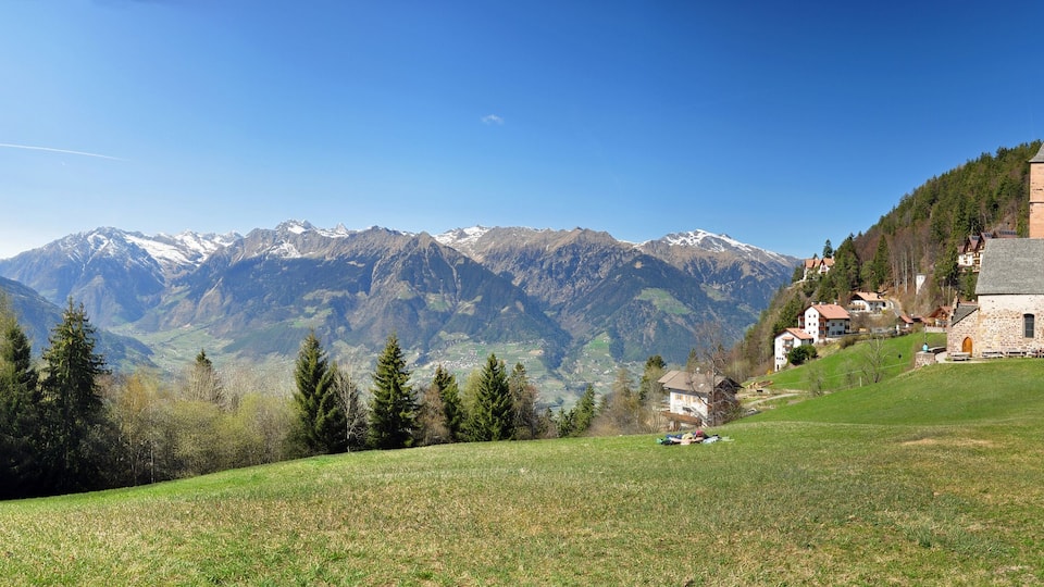 A church on a hill with a mountain backdrop.