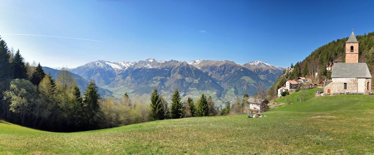 A church on a hill with a mountain backdrop.