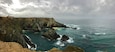 Un penya-segada costanera amb un far, una costa rocosa i mar tempestuós.