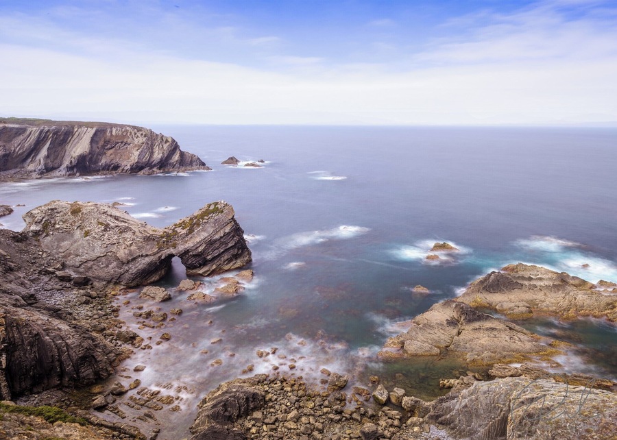 A rugged coastline with rocky outcrops and a clear view of the ocean.