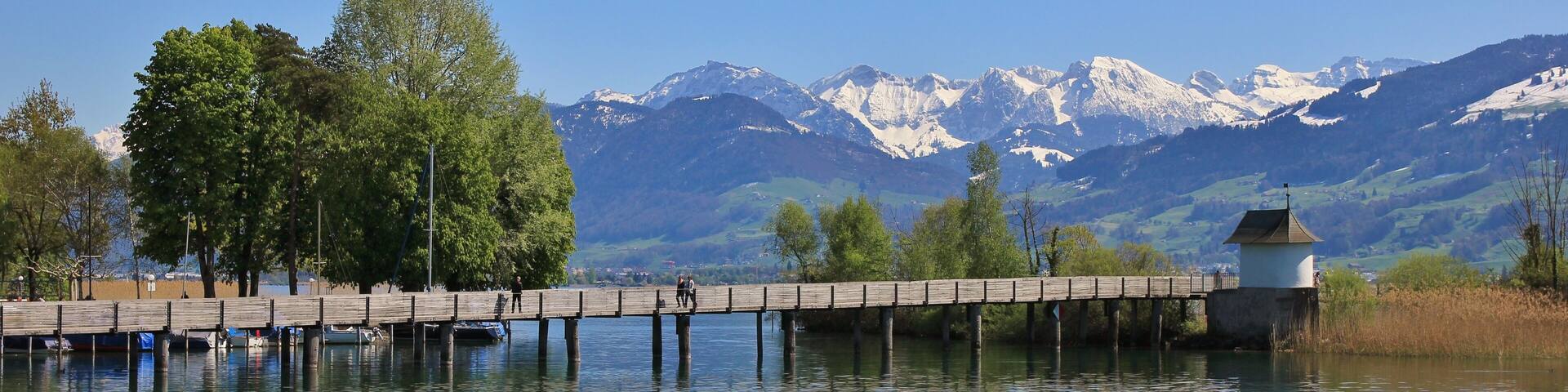 Timber gangplank in Rapperswil. Lake Zurichsee and snow capped mountains. Springtime.