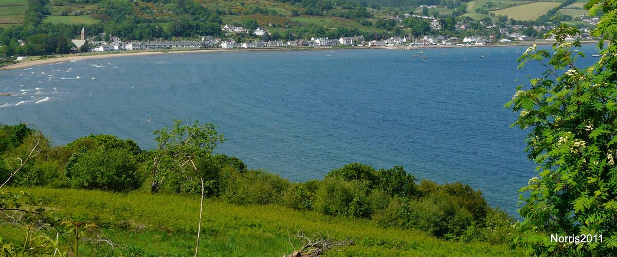 A coastal town with a church, houses, and boats on the water.