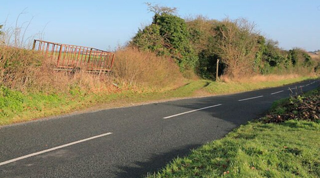 Wayfarer's Walk joins the road above Totford The Wayfarer's Walk crosses the B3046 at Totford (off picture right), follows this road up hill from the right, and doubles back on itself here. The farm truck seems to be doing its best to become part of the hedge.