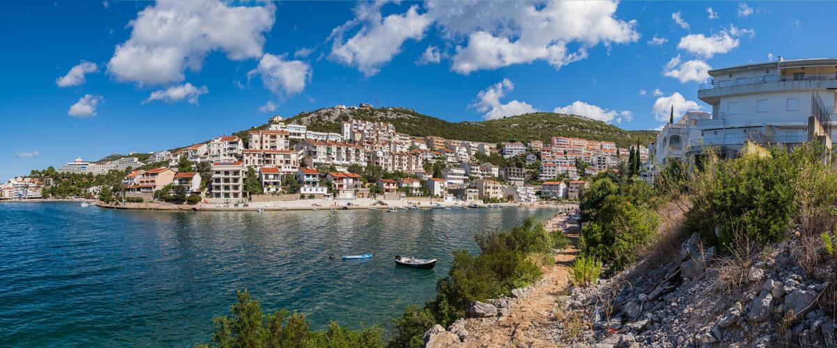 A coastal town with buildings on a hillside overlooking the sea.