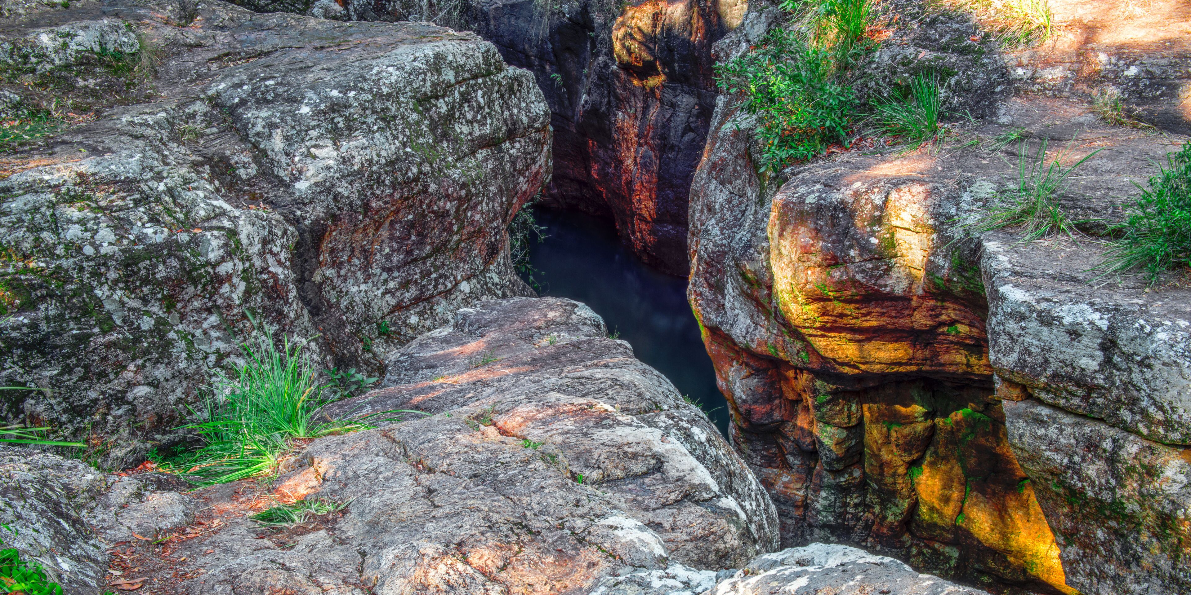 A rocky canyon with a narrow water channel.