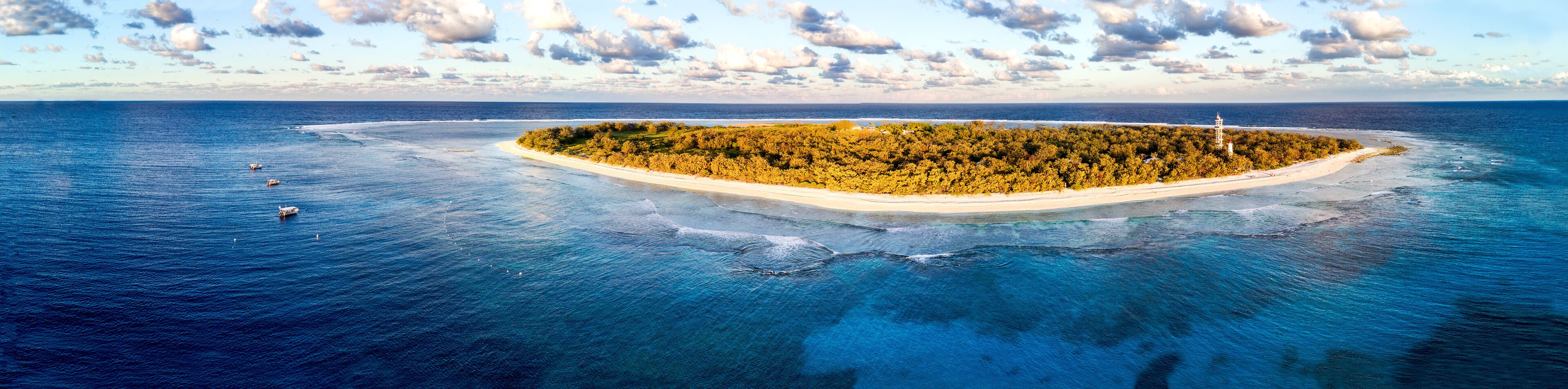 Aerial view of Lady Elliot Island in Queensland Australia with the coral reef in the foreground and clouds in the background.