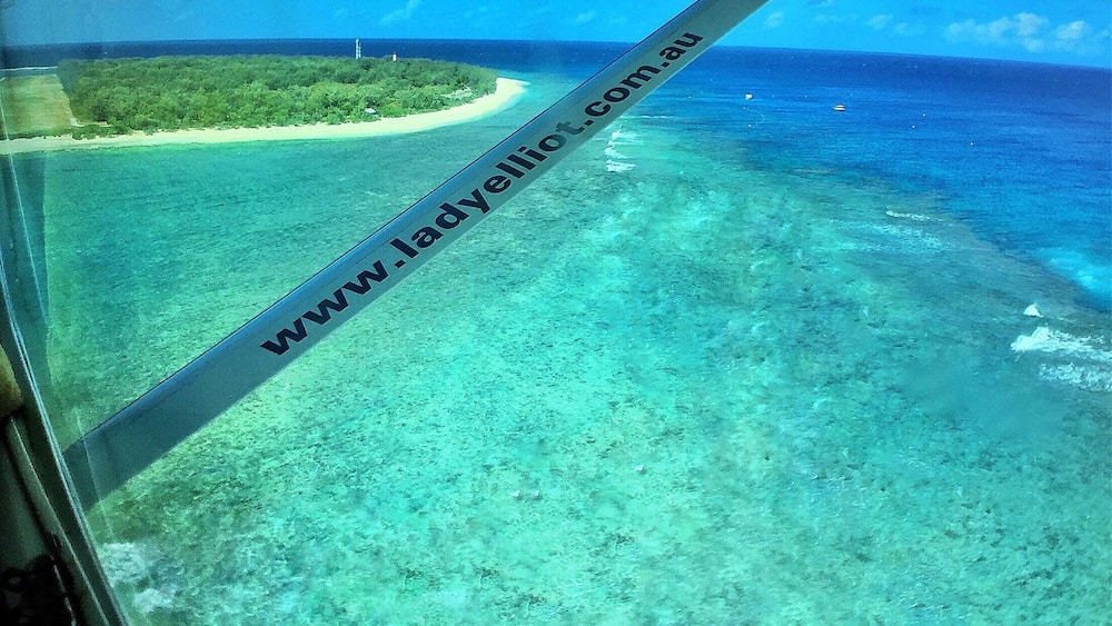 A clear view of a tropical beach with turquoise waters and a sandy shore.