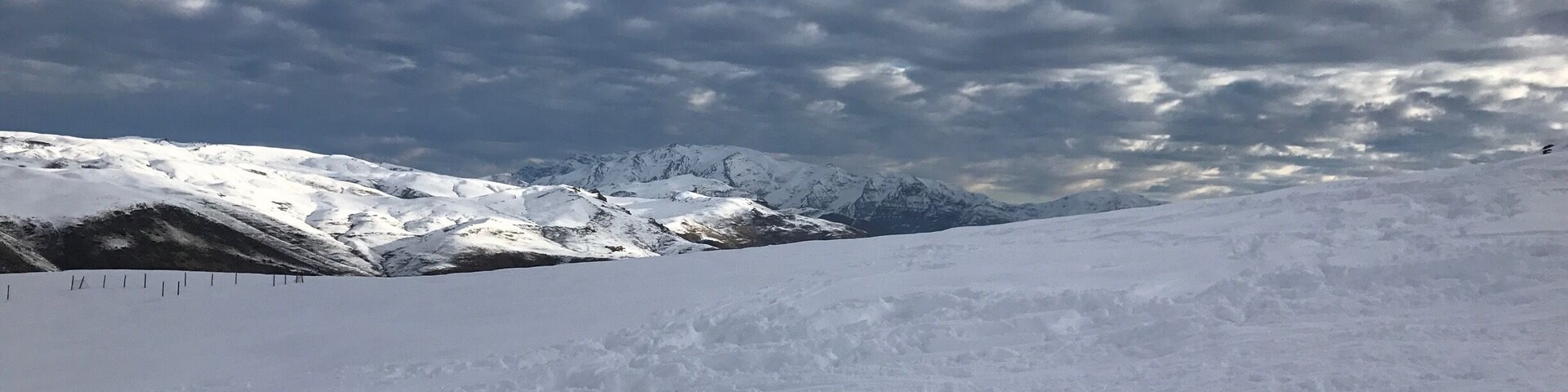 Cordilheira nevada sob um céu nublado.