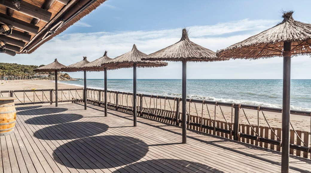 Mediterranean sea, spring sunny day, baech and umbrella terrace bar, Costa Dorada, Catalonia, Spain.