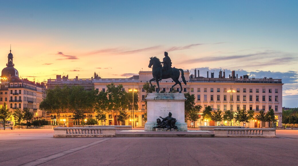 Una estàtua d'un home a cavall a una plaça, amb edificis al fons.