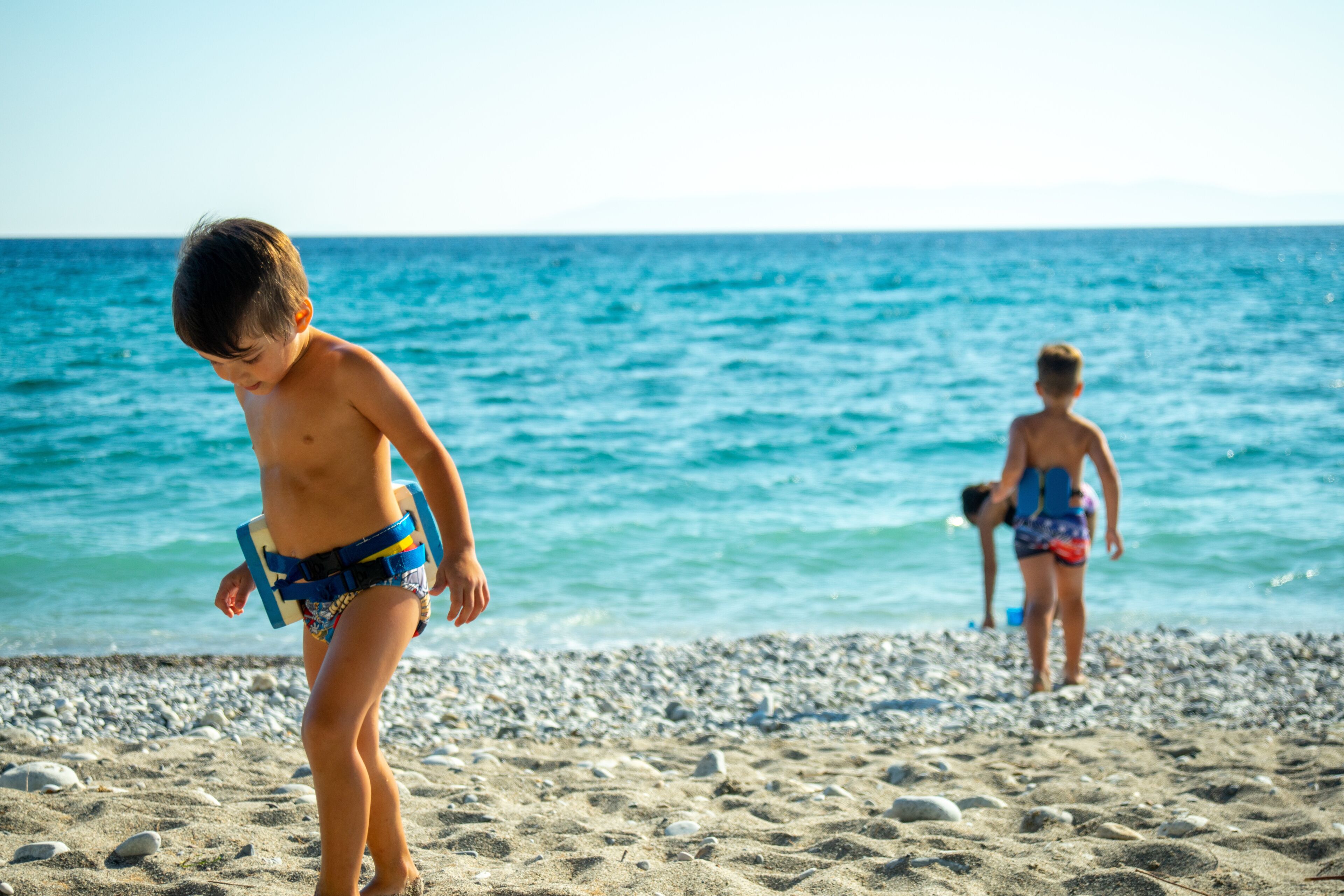 Toddler Boys playing at the beach of Kalamata, Greece